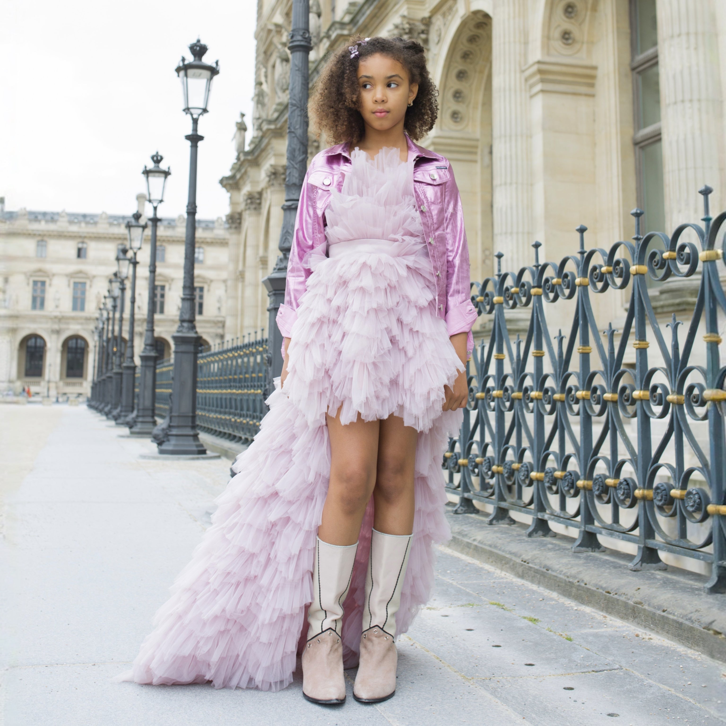 Fille portant une robe lavande en tulle à traîne, coupe asymétrique, look chic et moderne.